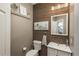 Stylish bathroom features wood accent wall, toilet, vanity with mirror, and decorative accents at 781 Deer Clover Cir, Castle Pines, CO 80108