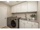 Convenient laundry room with appliances, sink, granite countertops, and ample cabinet space at 781 Deer Clover Cir, Castle Pines, CO 80108