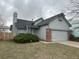 Gray two story home with brick-trimmed garage, well maintained lawn, and fresh landscaping at 4348 Sable St, Denver, CO 80239
