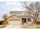 Charming two-story home with stone accents, a well-manicured lawn, and an attached two-car garage at 24505 E Wagon Trail Ave, Aurora, CO 80016