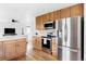 Bright kitchen featuring stainless steel appliances, wooden cabinets, and hardwood floors at 24505 E Wagon Trail Ave, Aurora, CO 80016