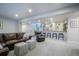 Open basement design including a bar, leather sofas, and staircase to the main level at 17548 Colonial Park Dr, Monument, CO 80132