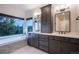 This bathroom features double vanities, a soaking tub and a large window with treed view at 17548 Colonial Park Dr, Monument, CO 80132