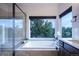 This bathroom features a soaking tub, large glass shower, and serene treed views at 17548 Colonial Park Dr, Monument, CO 80132