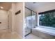 This bathroom features a soaking tub, a large shower, and a serene treed view at 17548 Colonial Park Dr, Monument, CO 80132