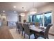 Dining room with a view of the tree tops and gray upholstered chairs that seat eight people around a wood table at 17548 Colonial Park Dr, Monument, CO 80132