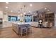 Open floor plan connecting the kitchen and living room, featuring a stone fireplace and hardwood floors at 17548 Colonial Park Dr, Monument, CO 80132