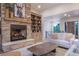 Cozy living room features a stone fireplace, built-in bookshelves, and stylish decor for comfortable living at 17548 Colonial Park Dr, Monument, CO 80132
