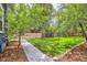 Lush backyard featuring a stone paver walkway, manicured lawn, and privacy fence with mature trees around the perimeter at 1519 16Th St, Boulder, CO 80302