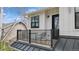 Cozy outdoor balcony with black metal railings, seating, and white board and batten exterior at 2948 S Clarkson St, Englewood, CO 80113