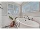 Bright bathroom with a freestanding tub, wood look flooring and large windows at 2948 S Clarkson St, Englewood, CO 80113