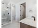 Bathroom featuring glass enclosed shower, vanity with quartz countertop and wood cabinetry at 8686 Pennycress Dr, Littleton, CO 80125
