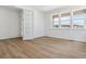 Bright bedroom with white walls and trim, wood floors, recessed lights, and double doors at 8686 Pennycress Dr, Littleton, CO 80125