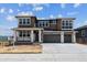 Two story home with large garage, neutral colors, white stone porch accents, and professionally landscaped front yard at 8686 Pennycress Dr, Littleton, CO 80125