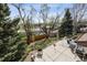 Backyard view from an elevated patio, mature trees, grass, shed, garden area, and neighborhood views at 8898 W Harvard Pl, Lakewood, CO 80227