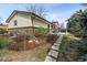 Landscaped backyard with stone pavers, lush greenery, and the home's exterior under a clear sky at 8898 W Harvard Pl, Lakewood, CO 80227