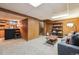 Open basement view featuring a bar area, stairs, and a cozy seating area with wood paneled walls at 8898 W Harvard Pl, Lakewood, CO 80227