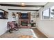 Inviting basement with brick fireplace, built-in shelving, and comfortable seating area at 8898 W Harvard Pl, Lakewood, CO 80227