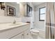 Bright bathroom with white fixtures, tiled walls, shower and bath combo, and modern vanity at 8898 W Harvard Pl, Lakewood, CO 80227