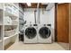 Functional laundry room with white washer and dryer, shelving, and tile flooring for easy maintenance at 8898 W Harvard Pl, Lakewood, CO 80227