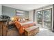 Inviting bedroom with a sliding glass door leading to a balcony, wood accents, and abundant natural light at 8898 W Harvard Pl, Lakewood, CO 80227