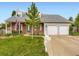 Traditional home featuring a well-manicured lawn, brick facade, and a two-car garage at 5456 E Briarwood Pl, Centennial, CO 80122