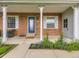 Inviting front porch with brick accents, white columns, and a decorative blue door at 5456 E Briarwood Pl, Centennial, CO 80122