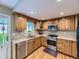 Charming kitchen with wooden cabinetry, stainless steel appliances, and a window above the sink at 5456 E Briarwood Pl, Centennial, CO 80122