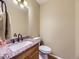 Cozy powder room features a granite countertop, framed mirror, and updated fixtures for a stylish and functional space at 5456 E Briarwood Pl, Centennial, CO 80122