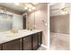 Bathroom featuring double sinks with a marble countertop and bronze fixtures and neutral paint at 19722 W 59Th Ave, Golden, CO 80403