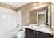 Bathroom features a dark vanity, a large mirror, and a shower/tub with white tiling at 19722 W 59Th Ave, Golden, CO 80403