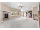 Open-concept living area with fireplace, plush carpet, lots of windows and a view of the kitchen at 19722 W 59Th Ave, Golden, CO 80403
