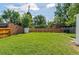 Large, grassy backyard featuring a tall wooden fence, mature trees and a storage shed for outdoor essentials at 740 Cherry St, Denver, CO 80220