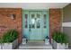 Close-up of the beautiful turquoise front door with decorative glass and stylish planters at 10743 W Turtle Mtn, Littleton, CO 80127