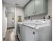 Functional laundry room featuring modern washer and dryer, built-in cabinets, and ample storage at 10743 W Turtle Mtn, Littleton, CO 80127