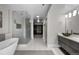 Contemporary bathroom featuring a glass-enclosed shower, modern tub, sleek vanity, and walk-in closet at 2523 N Humboldt St, Denver, CO 80205