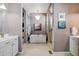 A modern bathroom featuring a soaking tub, walk-in shower, elegant lighting, and contemporary fixtures at 17240 Hop Clover Ave, Parker, CO 80134