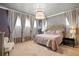 This bedroom features large windows with stylish curtains, a decorative headboard, and a unique pendant light fixture at 17240 Hop Clover Ave, Parker, CO 80134