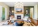 Comfortable living room with modern fireplace, a decorative mirror, contemporary seating, and statement lighting at 17240 Hop Clover Ave, Parker, CO 80134