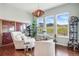 Comfortable sitting area with floor-to-ceiling windows and view of green spaces, accented by statement lighting at 17240 Hop Clover Ave, Parker, CO 80134