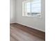 Bright bedroom featuring new hardwood floors and a large window with picturesque neighborhood views at 4735 Twelve Oaks Way, Castle Rock, CO 80104