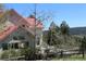 Backyard view of a charming deck and exterior elevation with a red roof, with a mountainous landscape beyond at 28650 Cavan Ln, Evergreen, CO 80439