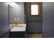 Bathroom with stylish wallpaper, sink with large mirror and a window above at 28650 Cavan Ln, Evergreen, CO 80439