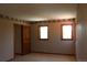 Bedroom featuring tile floor, two windows and doorway with doorframe at 28650 Cavan Ln, Evergreen, CO 80439