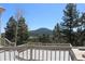This outdoor deck offers panoramic views of the surrounding evergreen trees and distant mountain range at 28650 Cavan Ln, Evergreen, CO 80439