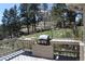 Relaxing deck features a built-in grill, perfect for outdoor entertaining amidst a scenic wooded backdrop at 28650 Cavan Ln, Evergreen, CO 80439