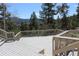 Expansive wooden deck surrounded by lush trees, offering a serene outdoor retreat for relaxation and entertaining at 28650 Cavan Ln, Evergreen, CO 80439