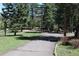 A scenic driveway winds through a green, grassy landscape, with mature trees providing privacy at 28650 Cavan Ln, Evergreen, CO 80439