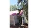 Quaint cottage featuring a red metal roof and wood siding, nestled amongst mature trees at 28650 Cavan Ln, Evergreen, CO 80439