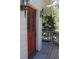 A red front door with windows and black hardware is accented by exterior lights and a gray wood porch at 28650 Cavan Ln, Evergreen, CO 80439
